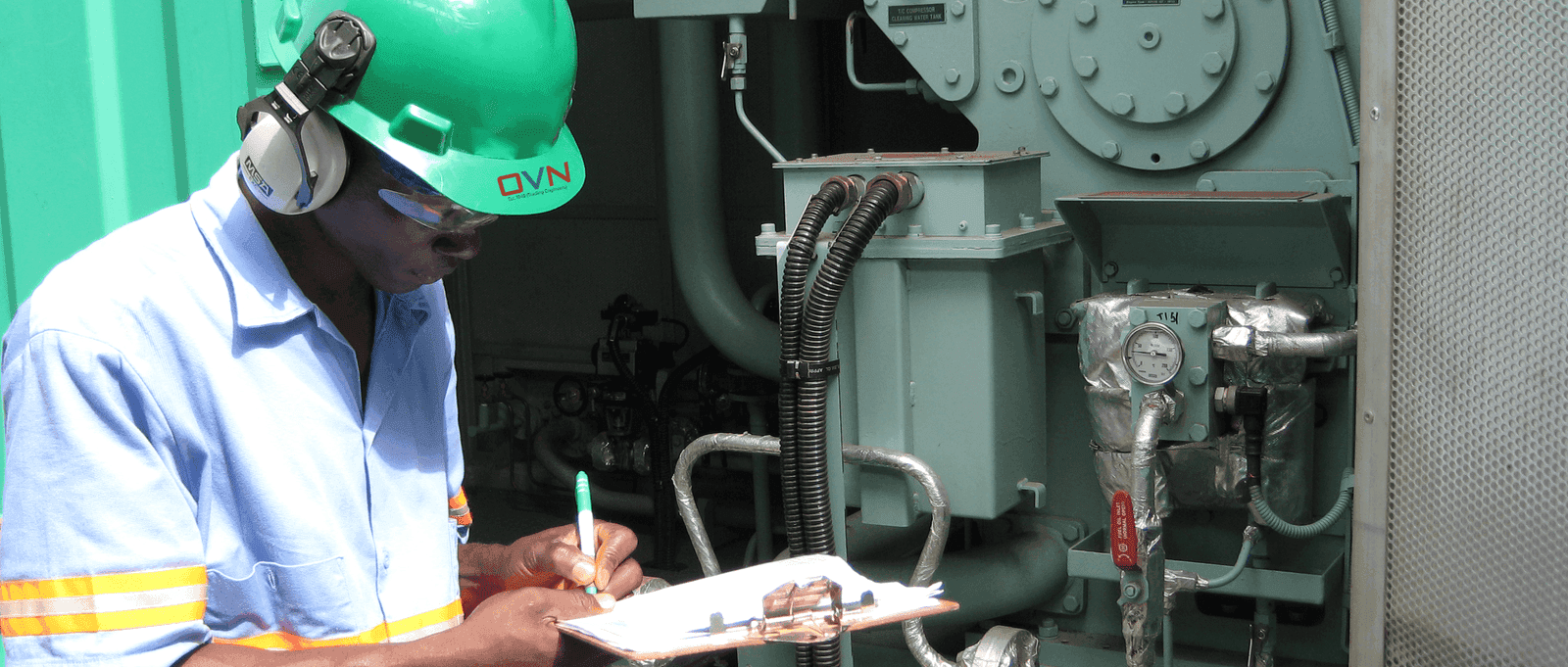 OVN field engineer with clipboard inspecting a generator on site